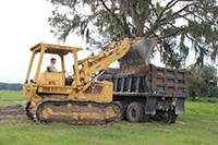 Photo of backhoe and dump truck in federal excess property program