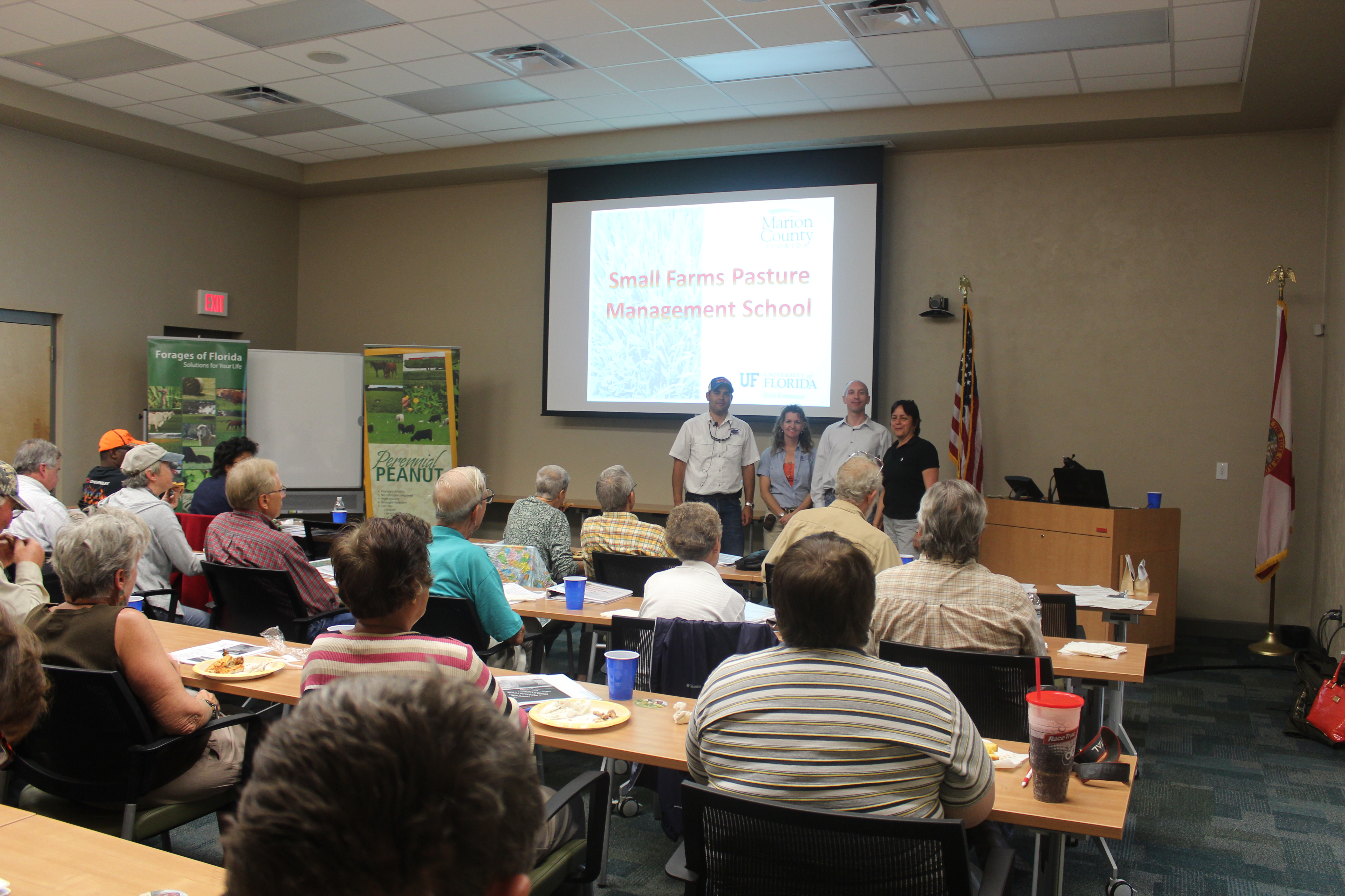 A group of people present about perennial peanuts to a full room